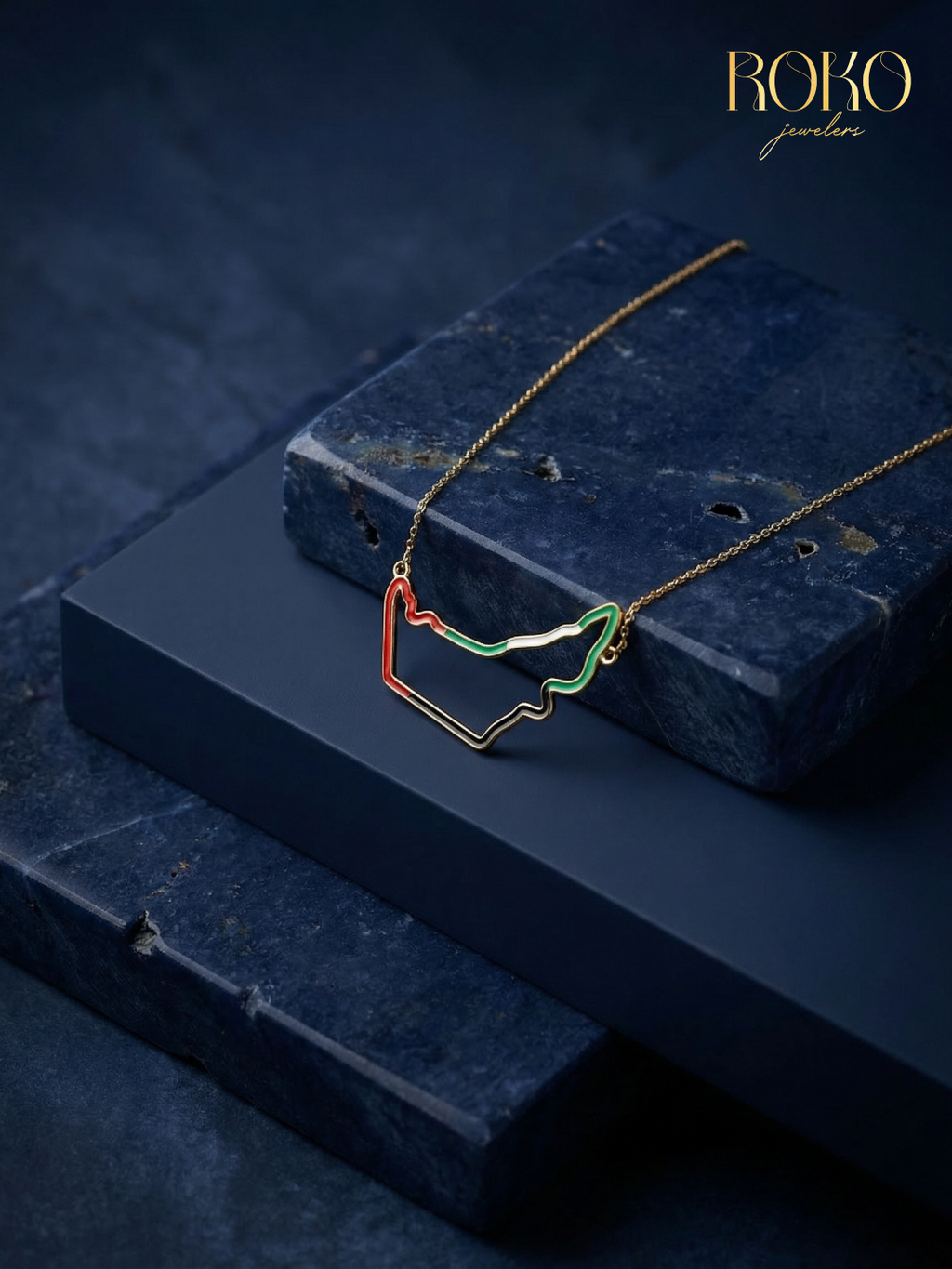 Close-up of UAE map necklace — red and green enamel outline on 18K gold