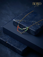 Close-up of UAE map necklace — red and green enamel outline on 18K gold