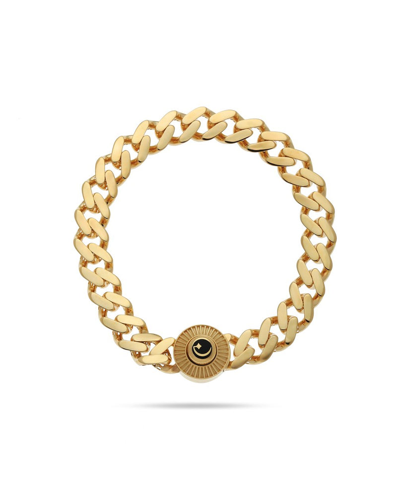 Gold chain bracelet with a black eye charm on a white background