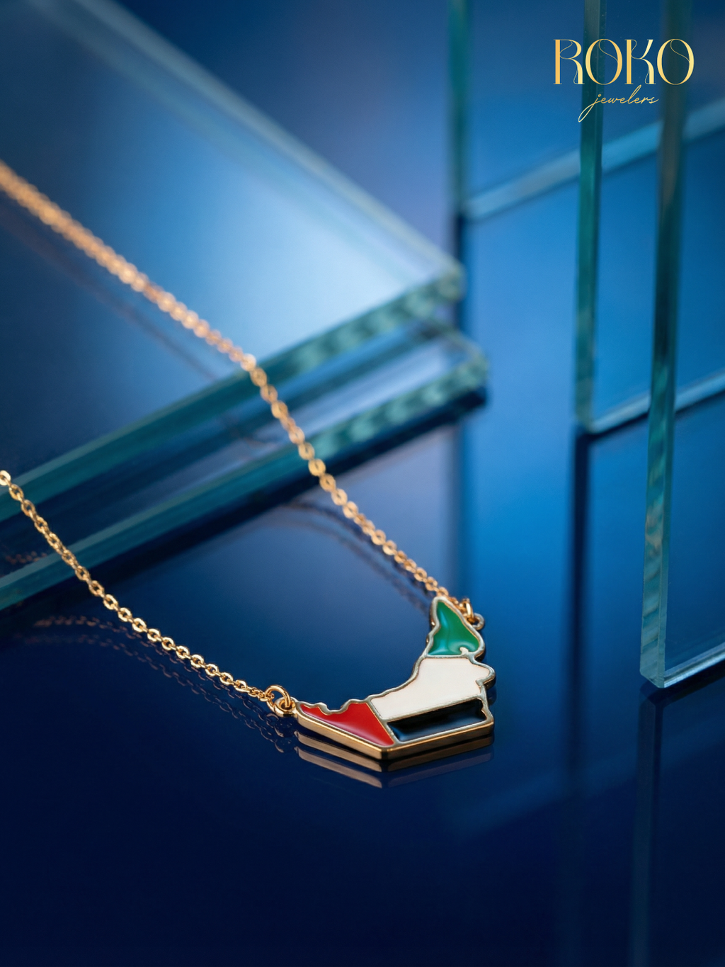 UAE map necklace in 18K gold with UAE flag enamel fill — red, white, black and green — by ROKO Jewelers Dubai